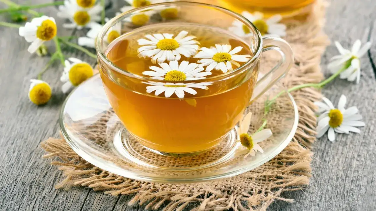 Tazza di tè alla camomilla con fiori galleggianti, un rimedio naturale per il tuo cane.
